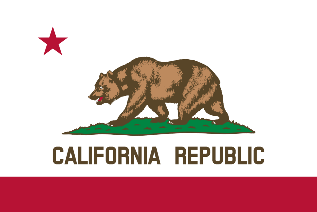 Flag of the U.S. state of California, composed of a white background with a red horizontal band across the bottom, text "California Republic." a brown California Grizzly Bear walking on green grass, and a lone, red star positioned at top-left, over the bear's head.